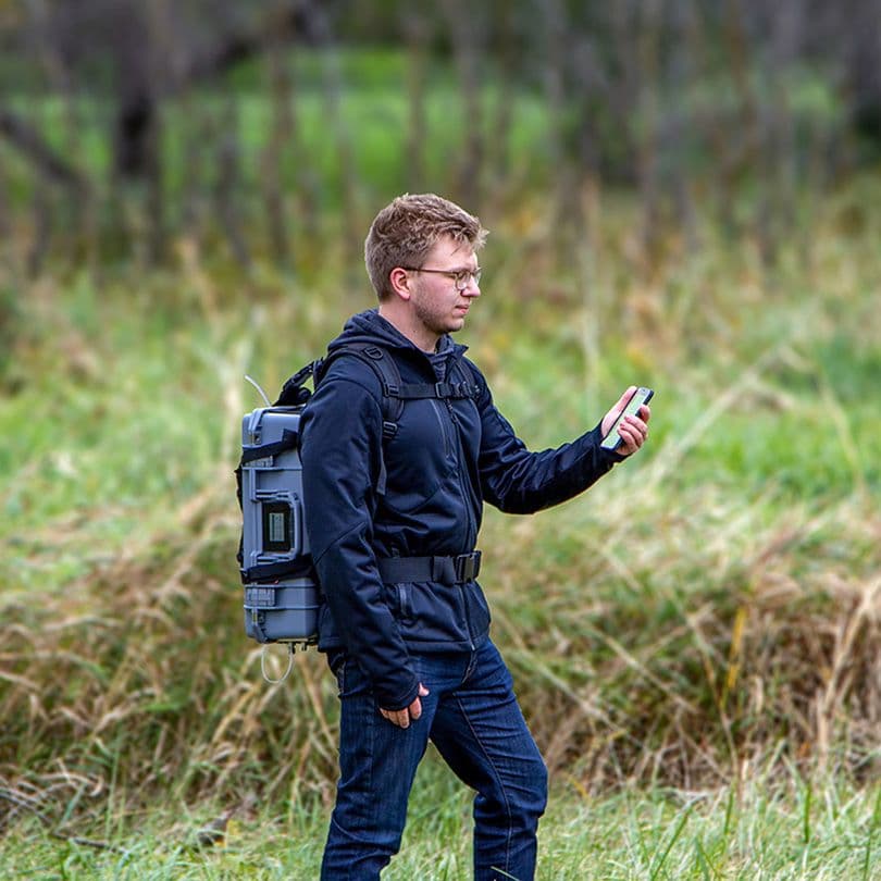 wearing a portable tga on his back while measuring in the field
